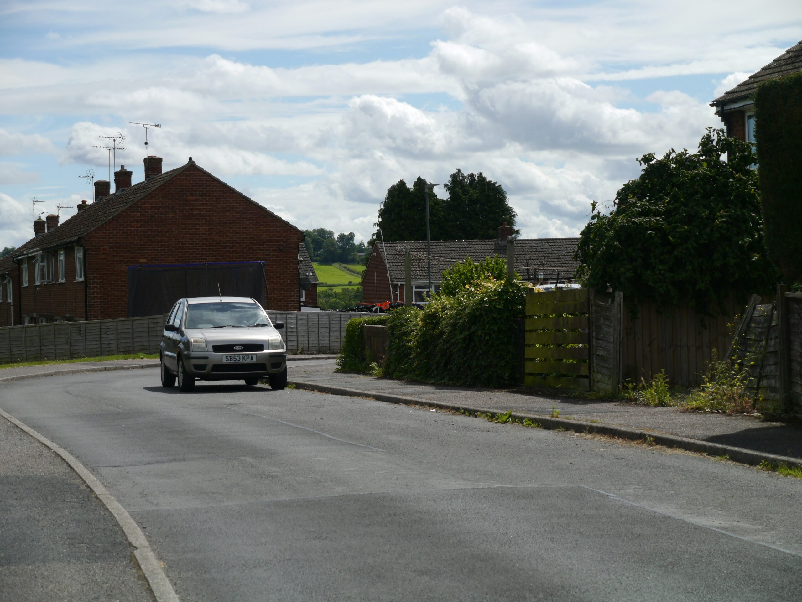 Curved residential road with kerbs and footways in a Derbyshire village, the kind of street Manual for Streets covers
